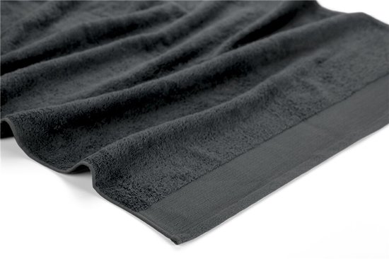 Detail van een antracietkleurige handdoek met een subtiele weefstructuur en een verstevigde rand.