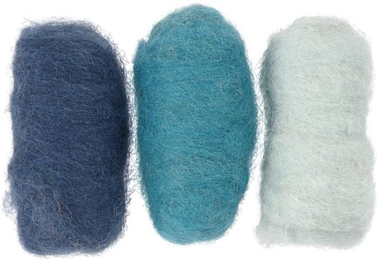 Trois pelotes de laine cardée lâches dans les couleurs bleu foncé, turquoise et bleu clair.