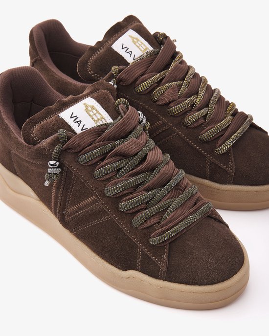 Close-up van bruine suède VIA VAI sneakers met veters en beige zool.