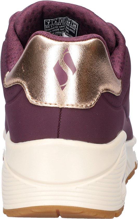 Achteraanzicht van een paarse Skechers sneaker met een gouden hieldetail met S-logo en een witte zool.