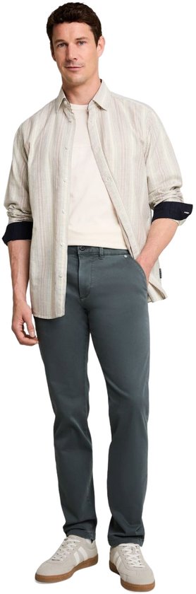 Man in een licht gestreepte blouse, crèmekleurig T-shirt en donkergroene chino.
