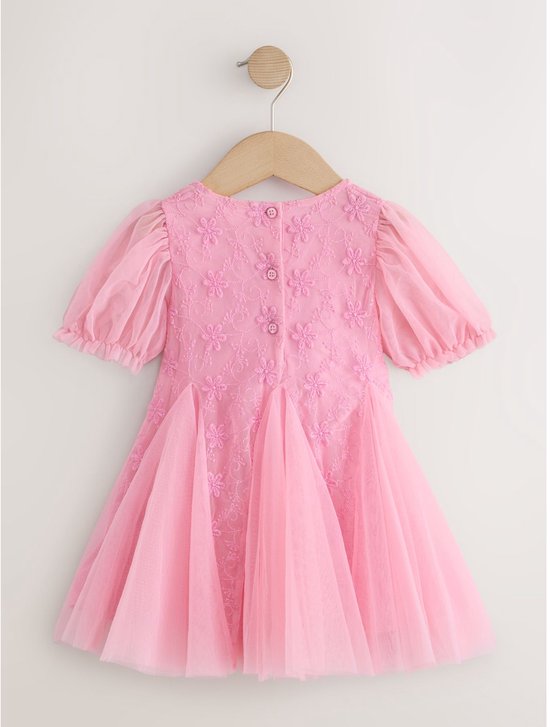 Roze feestjurk met geborduurde bloemen, pofmouwen en tule rok, achterkant met knopen.