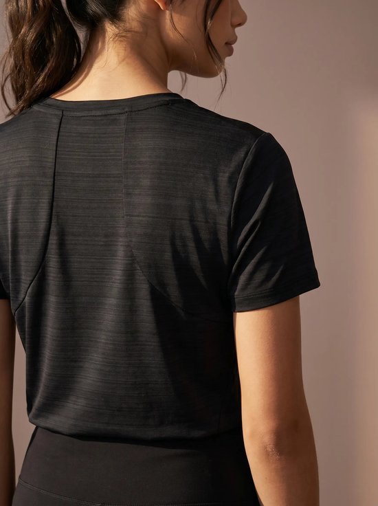 Achterkant van een donkerblauw sportshirt met korte mouwen, met contrasterende naden.