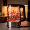 Glazen waterkoker met zwart handvat en RVS voet, met rood licht en borrelend water.