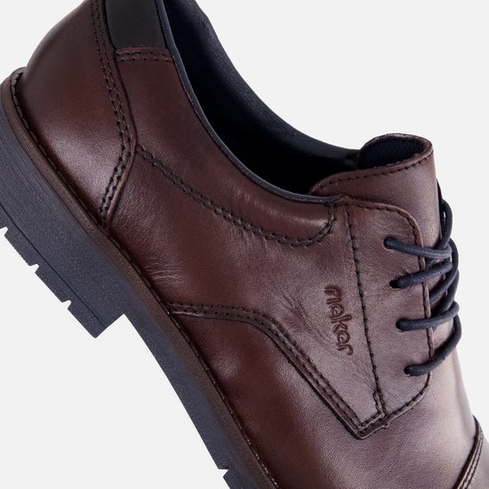 Detail van een bruine leren Rieker veterschoen met donkerblauwe veters.