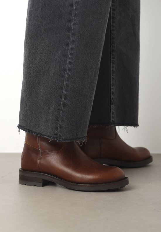 Cognac leren enkellaars met gesp, gedragen met een cropped jeans.