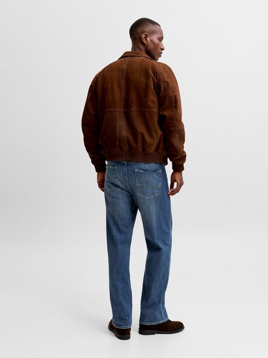 Man van achteren gezien, draagt een bruine jas en rechte blauwe jeans.