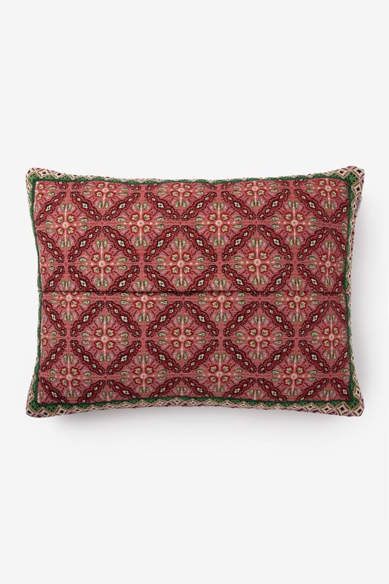 Kussen met een roze achtergrond en een veelkleurige mozaïekprint in rood, groen en beige. Met groene bies en gevlochten rand.