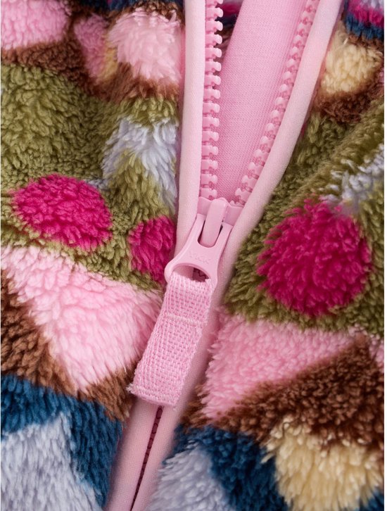 Close-up van de roze ritssluiting op een fleece jack voor baby's met een kleurrijk patroon.