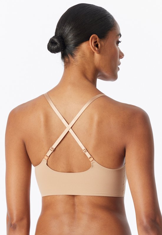 Achterkant van de beige, naadloze bustier met gekruiste bandjes en verstelbare sluitingen.