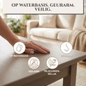 Hand op een geverfd oppervlak met iconen voor waterbasis, geurarm, VOS-arm en milieuvriendelijk. Tekst: Op waterbasis.