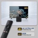 Een tv toont naast elkaar beelden van zeeleven en een vis; ernaast een zwarte TV Box en afstandsbediening, met 4K HDR-indicatoren.