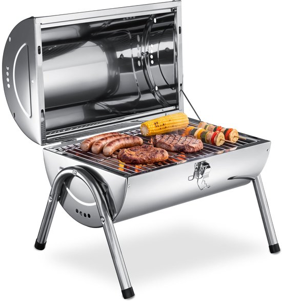 Zilverkleurige open barbecue met vlees, worst, mais en groentespiesen op de grill.
