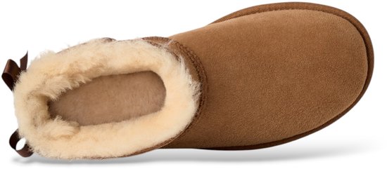Bovenkant van een bruine UGG laars met witte vachtvoering en bruine strik aan de achterkant.