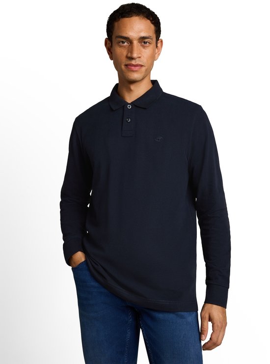 Man draagt een donkerblauw poloshirt met lange mouwen en jeans.