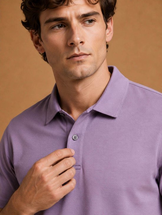 Man met donker haar, close-up van een lavendelkleurig poloshirt met kraag en knoopsluiting.