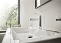 Chroom wastafelkraan met rechte hendel, water stroomt in witte wasbak.