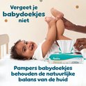 Een baby ligt op zijn rug, lachend. Een hand veegt met Pampers babydoekjes. Pak Pampers babydoekjes Aqua Soft Touch.