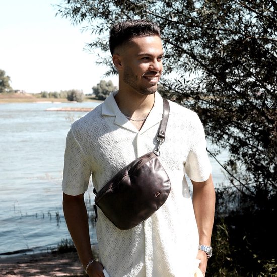 Man met donkerbruine leren heuptas, gedragen als crossbody.