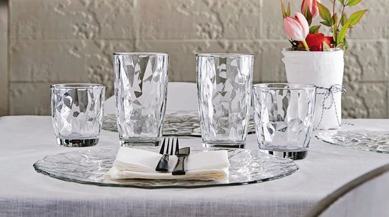 Ensemble de quatre verres à motif diamanté de différentes tailles, sur une table dressée.