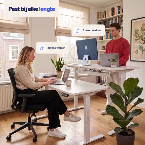 Man en vrouw demonstreren het zit sta bureau van Stane in zit- en staande positie.