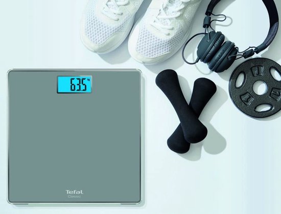 Balance Tefal grise avec des baskets blanches, un casque et des haltères.