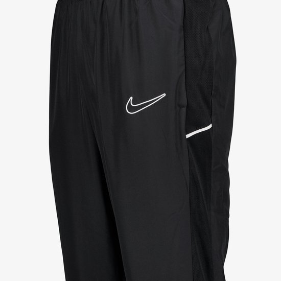 Detail van zwarte Nike trainingsbroek met meshpand aan zijkant en witte swoosh.