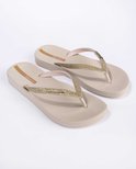 Paar beige Ipanema slippers met glitterband, reliëfzool en merknaam.
