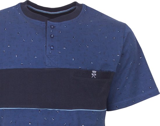 Close-up van donkerblauwe pyjamatop met stipjespatroon, borstband en logo.