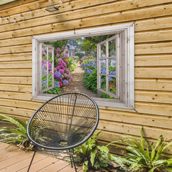 Une fenêtre avec volets ouverts montre un chemin de jardin avec des fleurs roses et violettes, sur une clôture en bois.
