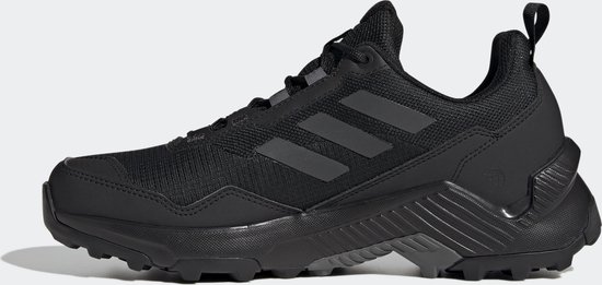 Een zwarte dames wandelschoen met zwarte Adidas-strepen op de zijkant en een lus aan de achterkant.