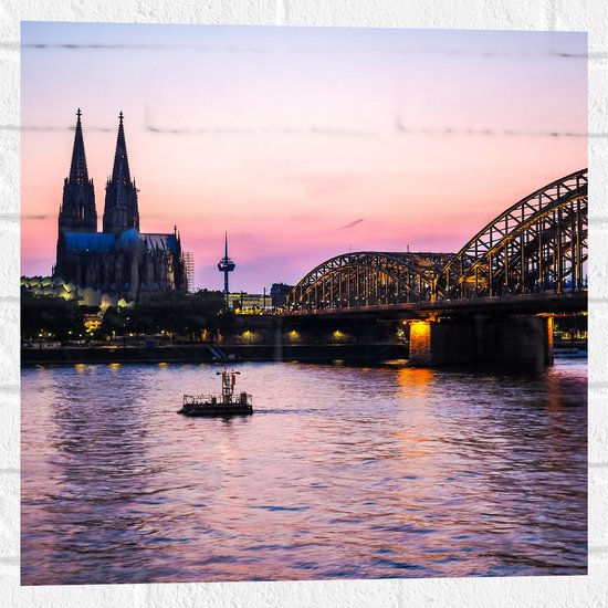Muursticker - Uitzicht op de Dom en Brug van Keulen tijdens de Avondzon in Duitsland - 50x50 cm Foto op Muursticker