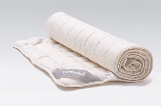 Wit Yumeko TENCEL™ dekbed, opgerold met geruite vulling en een label.
