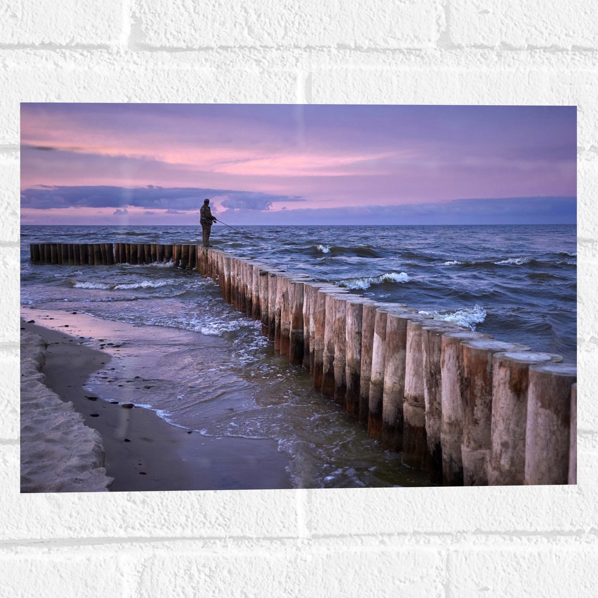 Muursticker - Man op Palen in de Wilde Zee tijdens het Vissen - 40x30 cm Foto op Muurstick