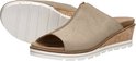Paar beige suède slippers, één met open teen en kurken sleehak, de andere op zijn zool.