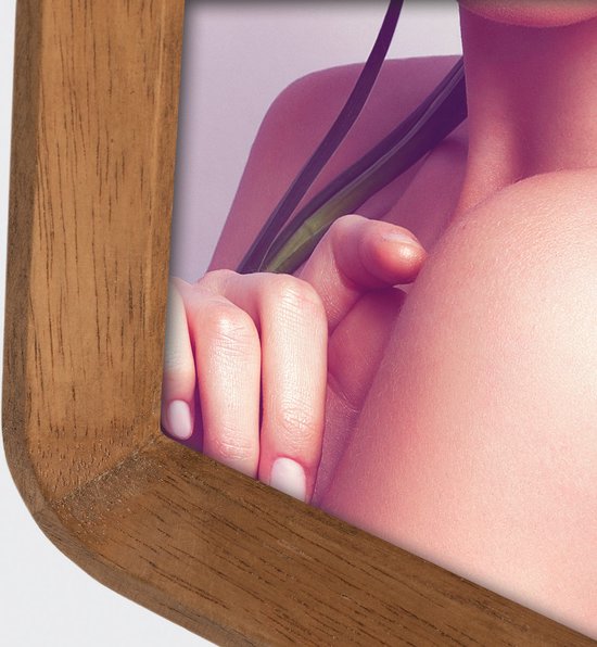 Close-up van een houten fotolijst met de schouder en hand van een vrouw.
