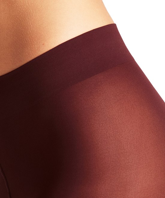 Close-up van de tailleband en heup van een dame in een donkerrode, matte panty.