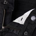 Sluiting van een donkergrijze jeans met rits en knoop.