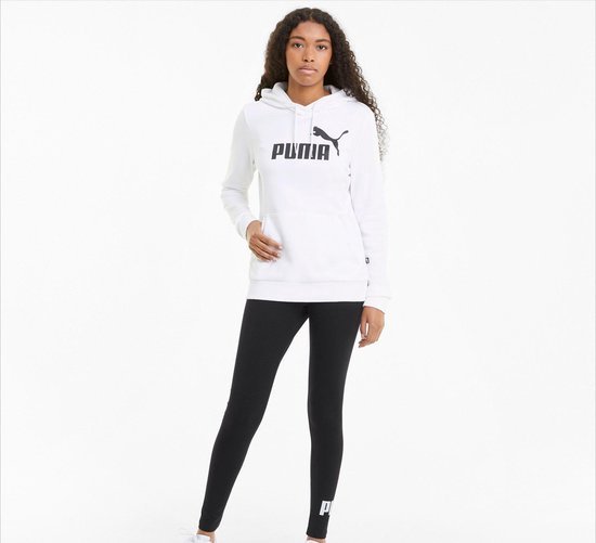 Model draagt een witte PUMA hoodie en zwarte PUMA-leggings met logo op de enkel.