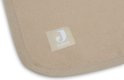 Close-up van de hoek van een biscuitkleurige babydeken met een Jollein logo label.
