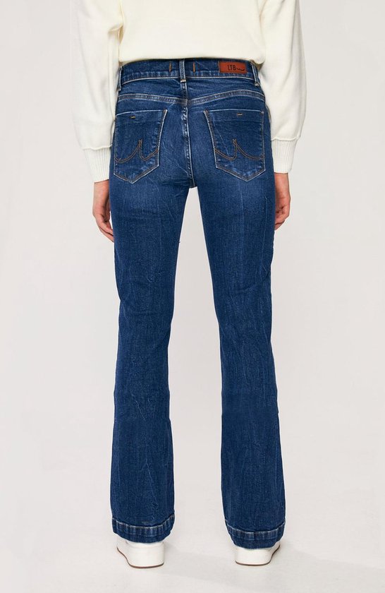 Model van de achterkant draagt een donkerblauwe flared jeans.