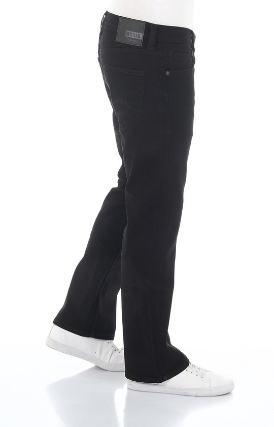 Zwarte jeans met bootcut pasvorm, van Mustang. De broek is aan de zijkant gefotografeerd, met witte sneakers.