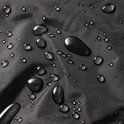 Close-up van een zwarte stof met veel waterdruppels.