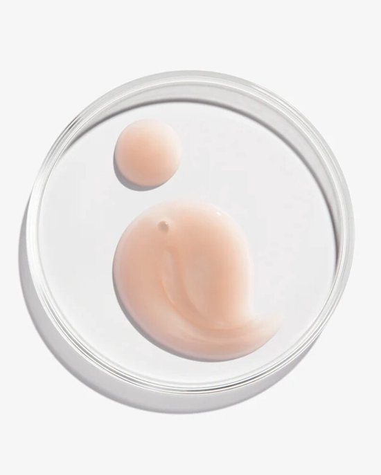 Une goutte et une vague de crème rose dans une coupelle en verre.