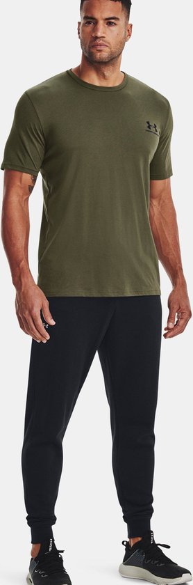 Man met olijfgroene korte mouw shirt en zwarte joggingbroek.