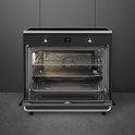 Zwart inductiefornuis met openstaande ovendeur, zichtbare roosters en bakplaten.