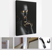 Mooie vrouw met zwarte en gouden verf op haar lichaam tegen een donkere achtergrond - Canvas Modern Art - Verticaal - 1195012708