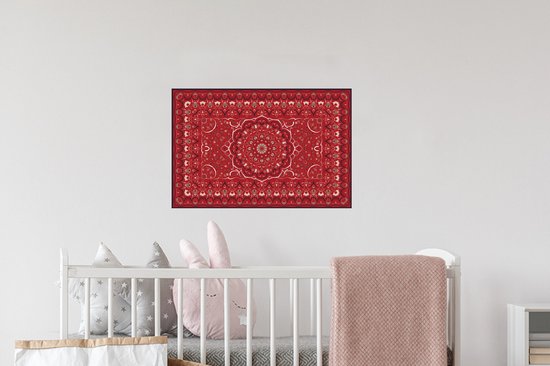 Une affiche de tapis persan rouge avec un design de mandala, accrochée au-dessus d'un lit de bébé.