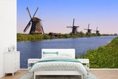 Papier peint vinyle - Vue sur les moulins à vent hollandais de Kinderdijk dans l'après-midi largeur 390 cm x hauteur 260 cm - Tirage photo sur papier peint (disponible en 7 tailles)