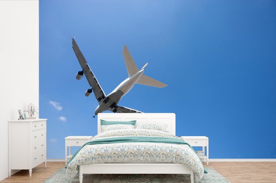 Behang - Fotobehang Vliegtuig die in de helder blauwe lucht vliegt - Breedte 525 cm x hoogte 350 cm
